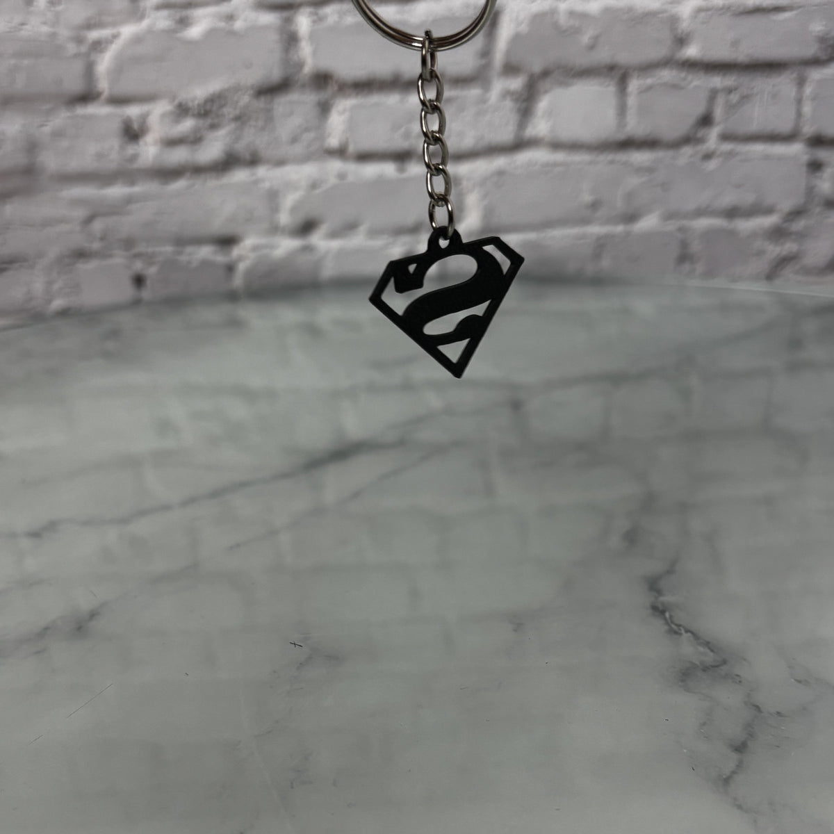 Porte-clés logo super-héros imprimé en 3D — Fil-O-Forme, vue 3